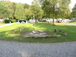 Bankjes en een gedoofd kampvuur op een kleine camping ardennen