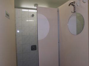 Een douchecabine met spiegel op een kleine camping drenthe